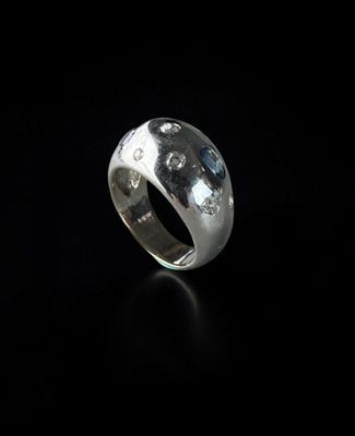 a close up of a silver ring on a black surface