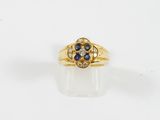 gros plan d'une bague en or avec des pierres bleues et blanches