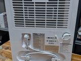 a white air conditioner sitting on a wooden table