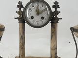 a clock sitting on top of a table next to two vases
