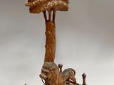 une statue représentant un oiseau perché au sommet d'un arbre