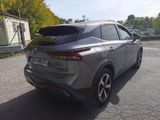 the rear end of a silver car parked on the side of the road