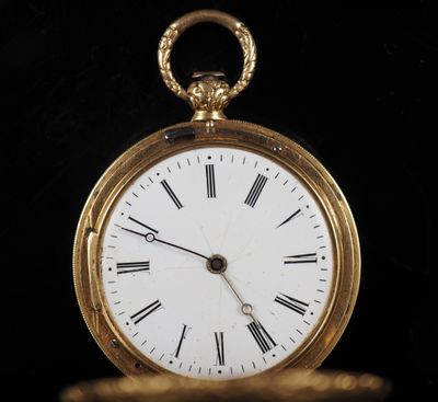 une montre de poche en or avec des chiffres romains sur le cadran