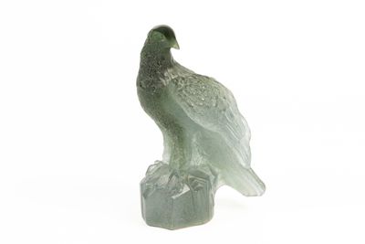 statue représentant un oiseau perché sur un rocher, posée sur un fond blanc