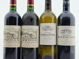quatre bouteilles de vin sont alignées sur une table