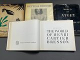 three books are sitting on a table, one is open and the other is closed