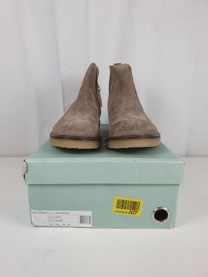 a pair of brown sued ankle boots sitting on top of a blue box