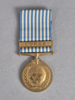 une image représentant une médaille d'or entourée d'un ruban bleu et blanc