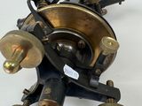 an old fashioned tattoo machine on a white surface