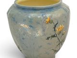 a blue vase with yellow flowers on it on a white background