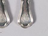 two spoons that are sitting next to each other on a table