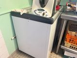 une petite cuisine équipée d'un lave-linge et d'autres appareils électroménagers