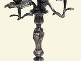 a silver candelab with three birds on it