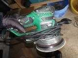 a person holding a corded sander in their hand