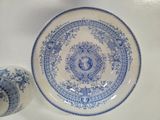 a blue and white plate and a vase on a table