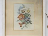 une image représentant un tableau de fleurs dans un cadre posé sur une étagère
