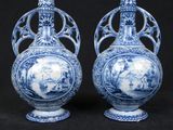 pair of blue and white vases on a black background