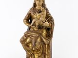 a gold statue of a woman holding a cat on a white background