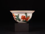 un bol blanc orné de motifs verts et orange