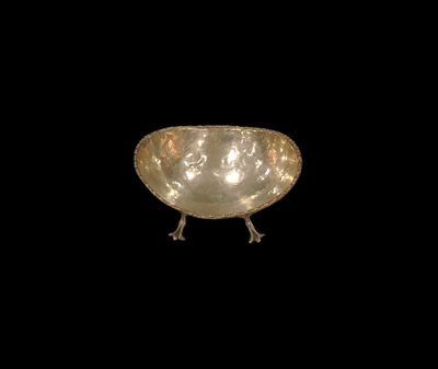 a silver bowl that is sitting on a black surface