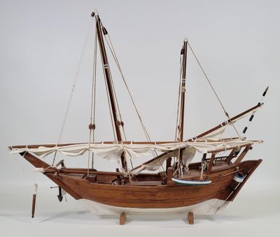 a wooden model of a sail boat on a white surface