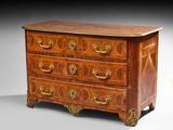 une commode ancienne avec un plateau en bois et des poignées en laiton