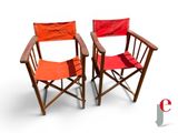 two red chairs sitting next to each other on a white surface