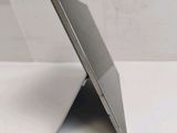 the back view of a silver tablet computer sitting on top of a white table