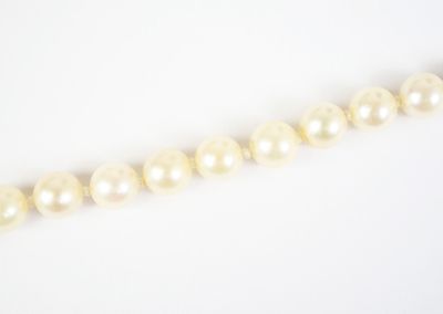 a close up of a strand of pearls on a white surface