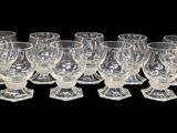 six verres à vin transparents alignés sur un fond noir