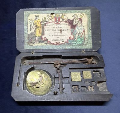 une petite boîte contenant une pièce, posée sur une surface bleue