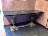 a black marble table with two vases on it