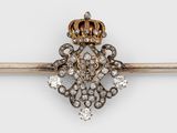un gros plan d'une broche ornée d'une couronne