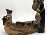 a figurine of a woman sitting in a boat