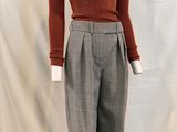 une photo d'un mannequin portant un pull marron et un pantalon gris
