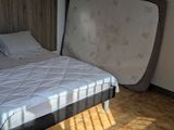 a bed in a room with a wooden headboard and white sheets
