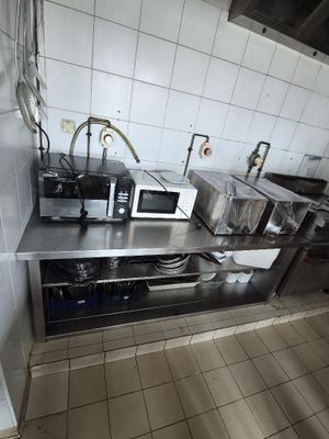 une petite cuisine avec de nombreux appareils électroménagers posés sur le plan de travail