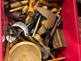 une boîte rouge posée par terre et remplie de divers outils