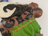 toy figurines of a man in a hawaiian dress with a gold coin in his hand