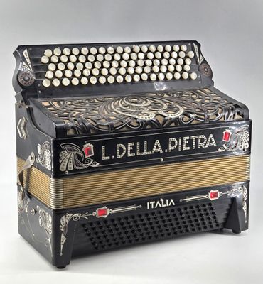 an old black and gold accordion sitting on top of a white table