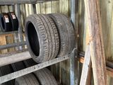 des pneus empilés sur une étagère dans un garage, avec une échelle à côté
