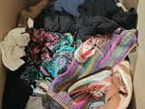 a cardboard box filled with clothes and a pair of shoes