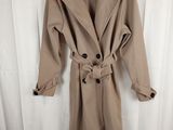 the coat is tan and has black buttons on it