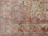 an antique rug with a red and beige design on a white background