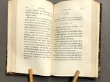 an open book sitting on top of a table next to a pair of wooden sticks