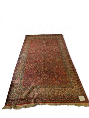 un tapis oriental orné d'un motif rouge et vert sur fond blanc