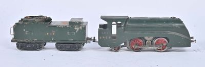 un petit train vert posé à côté d'un autre petit train sur une surface blanche