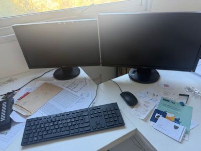 un bureau équipé de deux écrans et d'un clavier