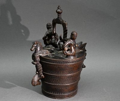 une statue en bronze représentant un homme et deux enfants dans un seau