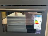 une personne en train de prendre une photo d'un four dans la cuisine